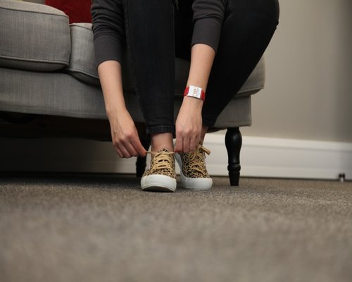 A person putting on comfortable walking shoes at home